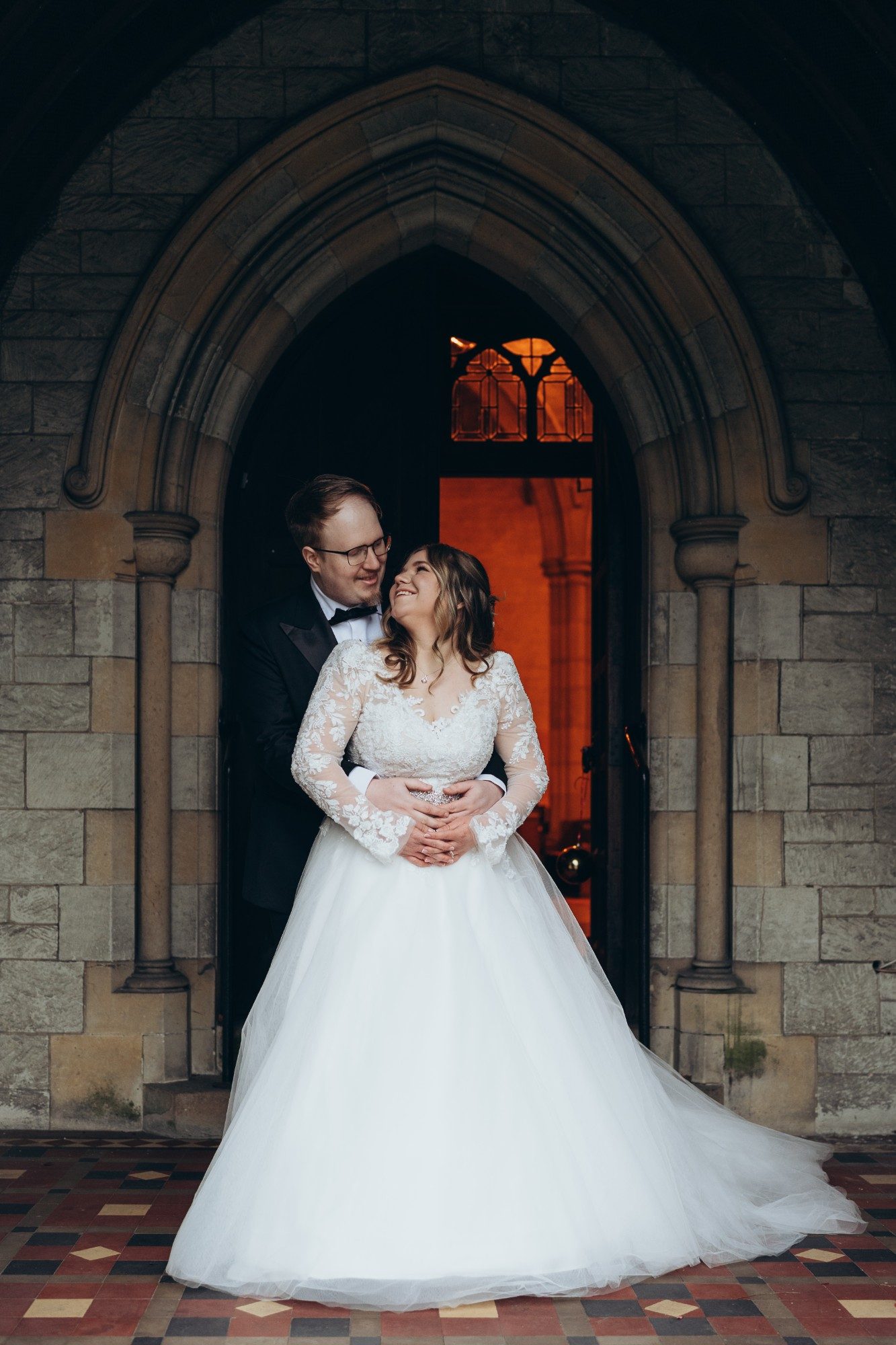 Bride and groom in the Gothic doorway of St John the Evangelist Church, Caterham Valley